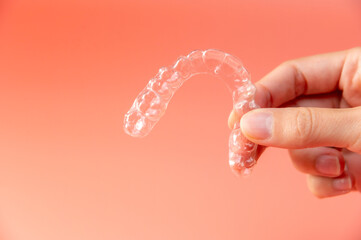 Hand hold invisible aligners plastic braces dentistry retainers to straighten teeth temporary...