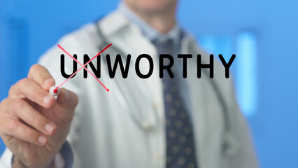 Doctor is crossing out the word unworthy written on a transparent screen with a red marker in a hospital setting, suggesting a concept of worthiness, value, or overcoming negative self perception
