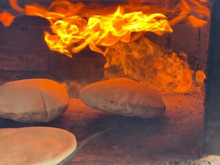 Baking bread in a clay oven, traditional method.