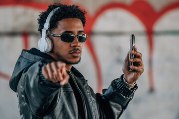 young latin man with headphone, listening music