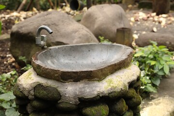 Stone washbasin in park on summer day