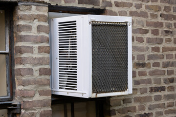 exterior view of air conditioning window unit installed in a vertical orientation to fit a small casement window