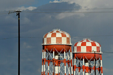 Checkered orange and white Elevated steel water storage tanks.