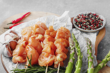 Raw chicken breast kebab. Raw sliced chicken breast on wooden sticks with asparagus and spices