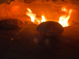 Burning clay oven at night used for baking.