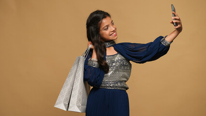 Portraits of kid girl wearing festive outfit and holding gift bags,gift boxes and garlands fro decoration