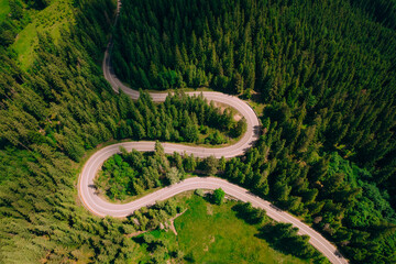 Top view of the road passing through the mountain and green forest.	
Curve asphalt road on mountain forest summer.