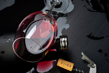 
Glass of red wine Cabernet Sauvignon from Chile supported on a bottle on the black wooden table...