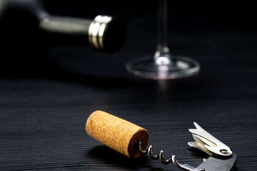 
Corkscrew with cork just removed from a red wine from CHILE, on a rustic wooden table with a...