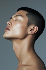 Profile of a young man with striking facial features and a serene expression captured in a minimalistic studio setting
