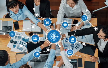 A top-down view of a collaborative business meeting featuring diverse professionals engaged in...