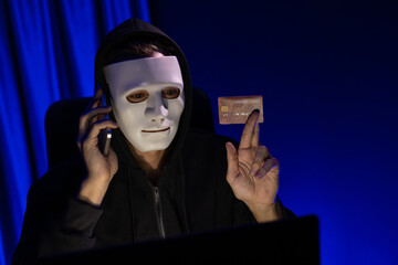 White criminal anonymous mask calling to credit card owner to threaten ransom with privacy...