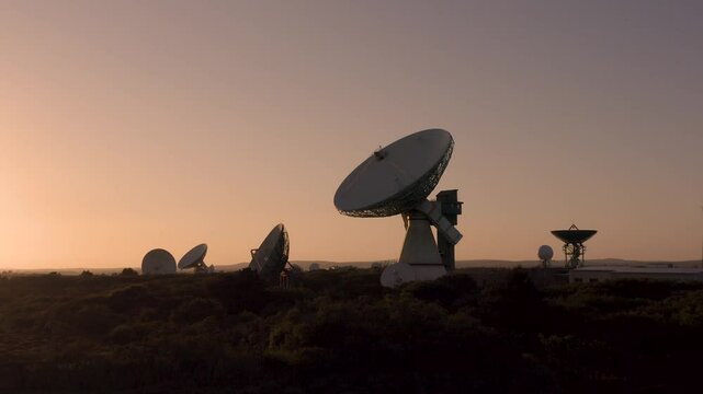 slow zoom in to large satellite dish receiving telecommunications globally