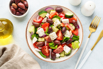 Greek salad, healthy food, mediterranean diet. Fresh vegetables, cheese and olive oil. Top view on white.