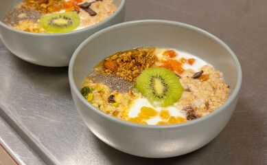 closeup fresh breakfast bowl greek yogurt with mixed dried fruits and fresh kiwi and granola cereal with chia seeds.