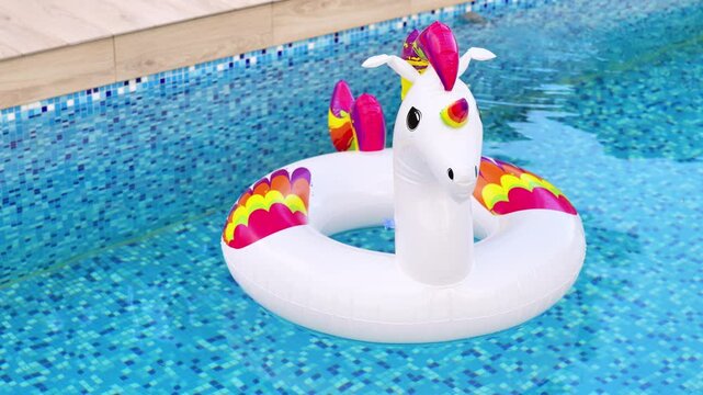 A vibrant inflatable unicorn float drifts in a sparkling blue swimming pool, perfect for summer fun and relaxation.