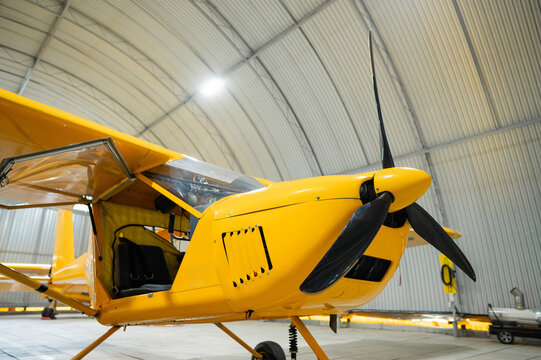 Yellow airplane glider in the hangar.  - Powered by Adobe