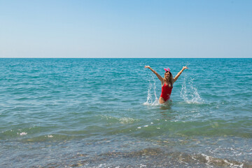 Yuletide Beach Bliss: Red Swimsuit and Santa Hat by the Shore