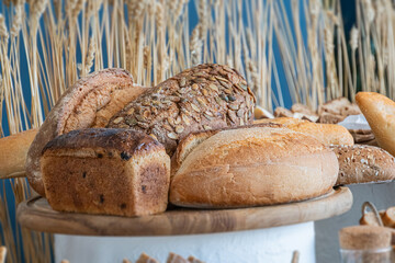 Wooden cutting board with assorted breads whole wheat, white loaf, flavoredfilled types in a rustic...