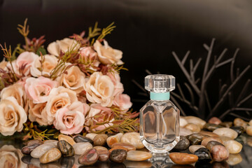 Decorative perfume product setup with flowers and pebbles in a modern setting.