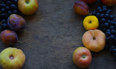Black grapes, yellow leaves, various fruits on a blackboard
