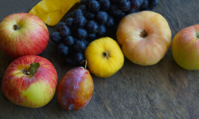 Black grapes, yellow leaves, various fruits on a blackboard
