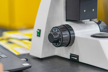Close-up of a complex, angled object with concentric rings and smaller dialsbuttons, possibly...