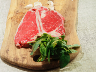 Luxurious T bone steak on a wooden cutting board with garlic and