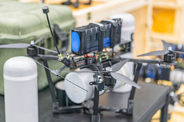 Close-up image of a grey-blue drone with four rotors, in a diffused artificial light workshop setting