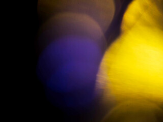 Abstract bokeh scene. Golden and blue glowing light leaks on black color background for design....