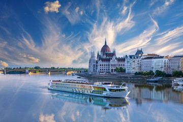 View of cruise ship on the Danube and Budapest Parliament under dramatic sky, Hungary