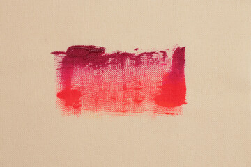 Grunge beige canvas flax denim fabric with red painting stain grain brush stroke smear blot. Art...