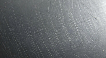 Macro view of scratched aluminum surface with directional lines and subtle wear texture