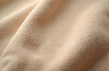 Beige faux suede fabric texture. Artificial leather with nap surface. Soft, fleecy upholstery with beige pastel colors, rough structure, pattern, close-up.