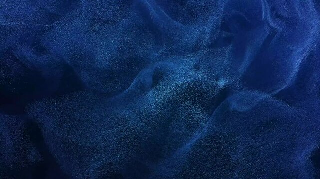 Abstract dark blue particles and dust moving fluidly in space, creating a swirling, mesmerizing background. Hypnotic visual effect. Seamless loop. 3D render