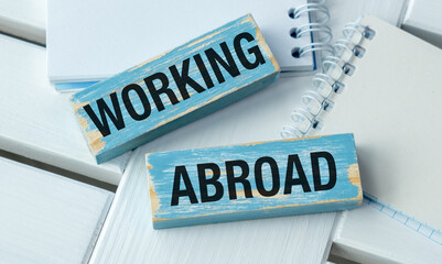 Two wooden signs that say working and abroad