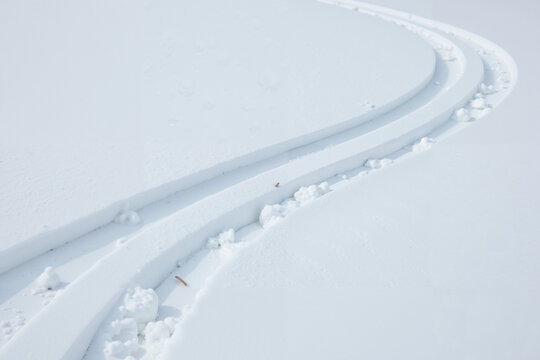 Serene, parallel tracks in pristine white snow representing a winter journey.

