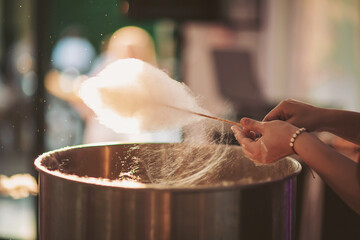 Cotton candy creation brings joy and sweetness to a lively carnival atmosphere at sunset in the...