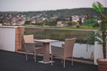 Fototapeta premium Serene evening on a modern balcony overlooking tranquil waters and a lush landscape, inviting relaxation and contemplation at dusk