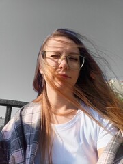 Portrait of a beautiful young woman with long hair in glasses.