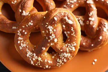Tasty pretzels with salt on table, above view