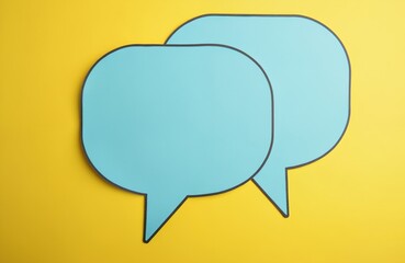 Fototapeta premium Two blue speech bubbles on yellow background, symbol conversation. Communication, dialogue concepts. Chat, talk, message, blank space for text. Social media network. Business, marketing, blog,