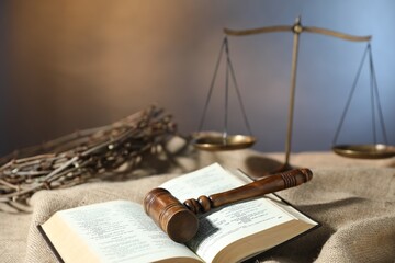Judge's gavel, Bible, crown of thorns and scales on burlap fabric, closeup