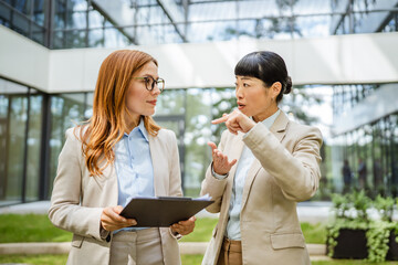 two multicultural female business woman collaborating new project