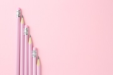 Many graphite pencils on pink background, flat lay. Space for text