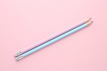 Two graphite pencils on pink background, flat lay