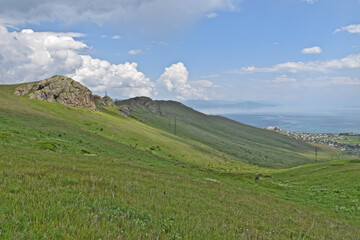 Obraz premium Breathtaking view of Lake Sevan from a hiking trail near the town of Sevan – a peaceful blend of water, sky, and surrounding mountains.