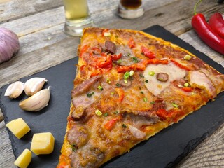 delicious slice of pizza lies on the table on a sliced board.