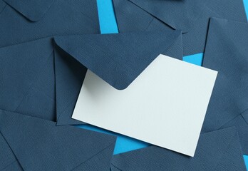Blank invitation card and envelopes on light blue background, flat lay. Space for design
