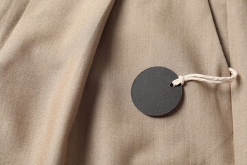 Cardboard tag on beige pants, above view